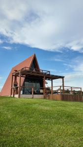 a building with a roof on top of a field at Chalé Pôr do Sol in Contenda +46 photos