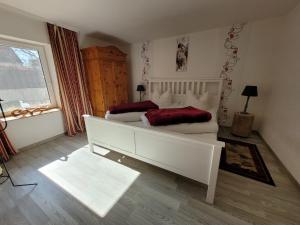 a bedroom with a large white bed and a window at Ferienwohnung 500m zum See in Vollrathsruhe