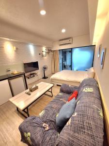 Zimmer mit Sofa, Bett und TV in der Unterkunft Moonlight 大陽台溫泉宿 in Jiaoxi