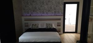 un dormitorio con una cama blanca con una ventana y una cama sidx sidx sidx en Chalet 2 moderne et chaleureux, en Saint-Louis