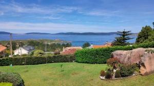 a large rock in a field with a view of the water at Mar infinito da Costa da Morte in O Pindo