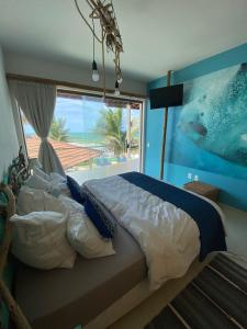 a bedroom with a large bed with a large window at Brisa Atlantica in Barra de São Miguel