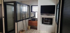 a living room with a television and a tv stand at Chalet 1 cosy et proche de la nature in Saint-Louis