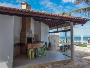 a patio with an outdoor kitchen with a view of the ocean at Brisa Atlantica in Barra de São Miguel