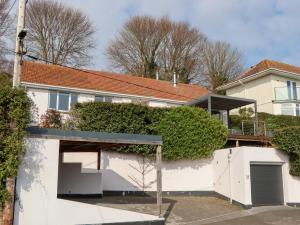una casa blanca con techo rojo en 15 Summerland Avenue, en Dawlish