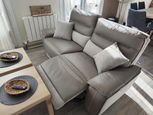 a leather couch sitting next to a coffee table at Mon petit paradis - Proche de la mer et Touquet in Camiers