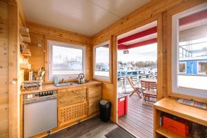 a kitchen with wooden walls and windows and a deck at Hausboot im Yachthafen Merzig in Merzig