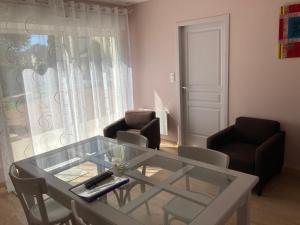 a living room with a glass table and two chairs at Maison Gille in Nuits-Saint-Georges +14 photos