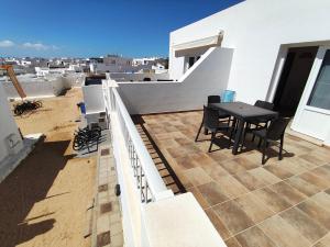 a table and chairs on the balcony of a house at Apartment Mar&Mar with terrace 50m from the beach in Caleta de Sebo