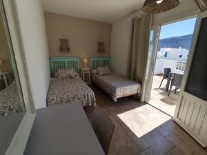 a small room with two beds and a balcony at Apartment Mar&Mar with terrace 50m from the beach in Caleta de Sebo