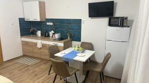 a kitchen with a table and chairs and a refrigerator at SpaGo Apartment in Hajdúszoboszló