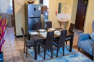 a dining room with a table and a refrigerator at Happy Trails Home- Nanyuki in Nanyuki