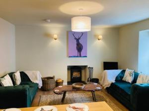 a living room with a couch and a fireplace at Stalkers Cottage in Spean Bridge