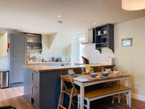 a kitchen with a island with a table and chairs at Stalkers Cottage in Spean Bridge