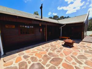 a building with a stone patio in front of it at Strathavon Cottage in Machadodorp