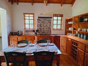 a kitchen with a table with wine glasses on it at Strathavon Cottage in Machadodorp