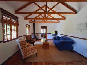 a living room with a blue couch and chairs at Strathavon Cottage in Machadodorp +1 photo