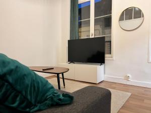 una sala de estar con TV de pantalla plana en un armario blanco en Vert Gallant - Ultra Central - Parking public - Lumineux, en Arras