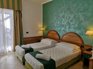 Postel nebo postele na pokoji v ubytování Hotel L'Aquila