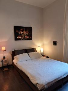 a bedroom with a bed with a painting on the wall at La Casa Del Podestà 65 in Florence