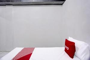 a bed with red and white pillows on it at Hotel O Villa A1 in Tretes
