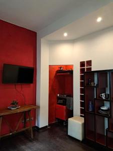 a living room with a red wall with a tv at La Casa Del Podestà 65 in Florence