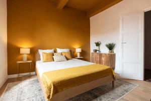 a bedroom with a large bed with a yellow wall at Maison Zellige - Rooftop - Gruissan Center in Gruissan