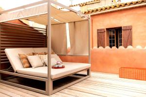 a porch with a swinging bed on a patio at Maison Zellige - Rooftop - Gruissan Center in Gruissan