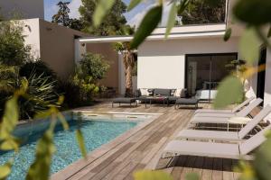 a patio with lounge chairs and a swimming pool at Villa Yuna Heated Swimming Pool Beach in Cap d'Agde +48 photos