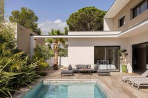 a backyard with a swimming pool and a house at Villa Yuna Heated Swimming Pool Beach in Cap d'Agde