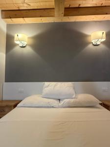 a bed with two lights on the wall at Conchiglia Doro in Civitanova Marche