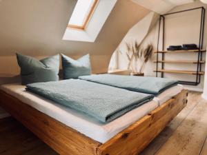 卡罗利嫩西尔stilfrei by Humble Homes的卧室里有一张木床，配有蓝色枕头