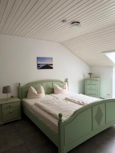 ミッセン・ヴィルハムスにあるFeWo Bergveilchen 631 im Ferienpark Oberallgäuの天井の客室の緑のベッド1台