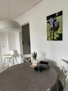 ミッセン・ヴィルハムスにあるFeWo Bergveilchen 631 im Ferienpark Oberallgäuの田んぼに立つ牛のいるテーブル付きの部屋