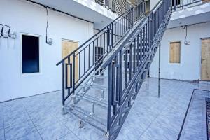GresikにあるOYO LIFE 91594 Bungah Residence Syariahのタイル張りの床の部屋にある金属製の階段