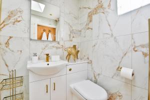 a white bathroom with a sink and a toilet at Luxury Cosy Central Detached Cardiff Bungalow with Free Parking in Cardiff +14 photos