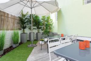 a patio with tables and chairs and an umbrella at Garden Suites in Thessaloniki