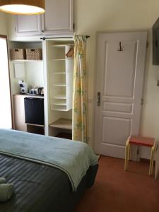 a bedroom with a bed and a door and a kitchen at La Pierrerie Bambou in Tourtour