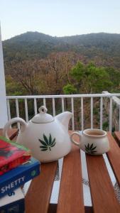 a tea pot and a cup on a wooden table at Buraans in Dehradun +19 photos