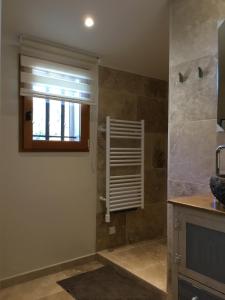 a bathroom with a shower with a window and a sink at La Pierrerie Bambou in Tourtour