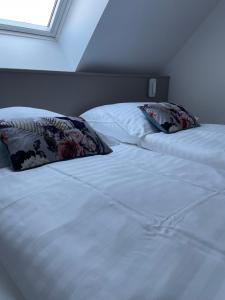 een wit bed met twee kussens erop bij La Clé des vignes 2 in Ribeauvillé