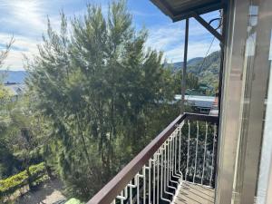 a balcony with a view of trees and the ocean at Condo in Green Valley Baguio in Baguio