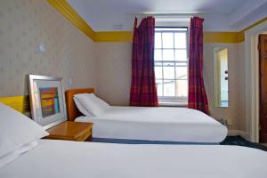 a hotel room with two beds and a window at Great White Horse Hotel in Ipswich