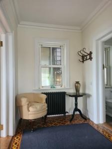 a room with a chair and a table and a window at Country home with a Pub, Restaurant & Brewery onsite ! in Rathcoffey