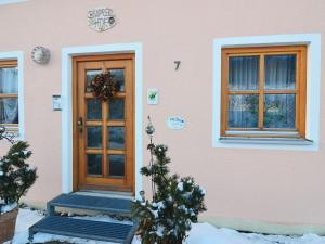 DietersdorfにあるLively Apartment with Sauna in Schonseeのピンクの家(木製のドア、窓2つ付)