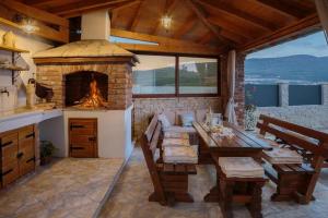 a living room with a fireplace and a table and chairs at Seafront Villa Noah with heated pool in Pridraga