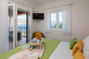 a bedroom with a bed with a view of the ocean at Seafront Villa Noah with heated pool in Pridraga