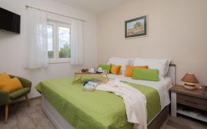 a bedroom with a green and white bed and a chair at Seafront Villa Noah with heated pool in Pridraga +31 photos