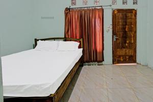 a bedroom with a bed and a open door at Hotel O Homestay Bang HajiNearLapangan Penujak ( Inen Gonggang) in Praya