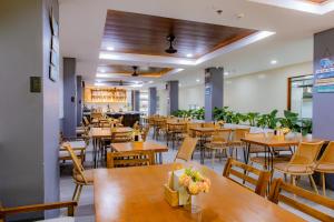 an empty restaurant with wooden tables and chairs at Coastal Breeze Hotel in Baler